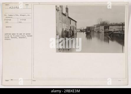 Downs e Pvt. Winger del Signal Corps sono visibili in questa foto scattata il 12 marzo 1919. L'immagine li cattura mentre consegnano pasti ai soldati di stanza al casual Depot di Nevers, in Francia, utilizzando un camion a motore per navigare attraverso un fiume allagato. Queste informazioni sono registrate nelle note del 7 gennaio 1919. Foto Stock