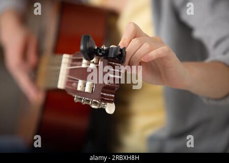 vista ritagliata di un musicista che sintonizza una chitarra Foto Stock