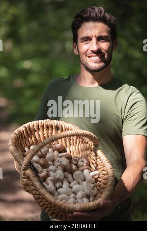 un uomo felice a caccia di funghi Foto Stock