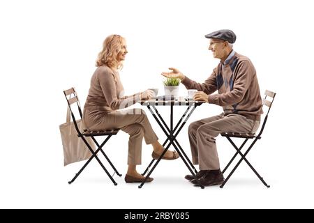 Un uomo anziano seduto a un tavolo e sorseggiando una tazza di caffè con una donna isolata su sfondo bianco Foto Stock