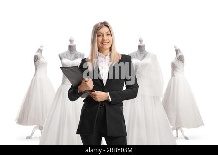 Wedding planner che tiene un appunti e sorride davanti a abiti da sposa isolati su sfondo bianco Foto Stock