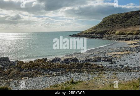 La piccola spiaggia di ciottoli/sabbia sul lato destro della Baia di Port Eynon con scogliere dietro la penisola di Gower e la costa del galles meridionale Foto Stock