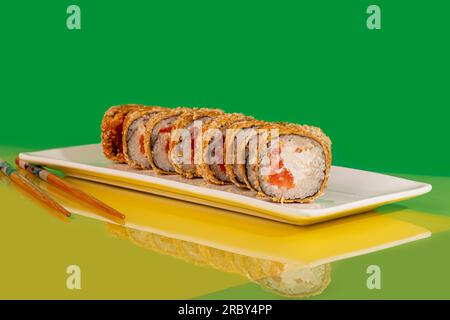 Sushi, panini con caviale, gamberi, tonno e avocado e formaggio Philadelphia, su un piatto bianco. Su uno sfondo colorato. copia spazio Foto Stock