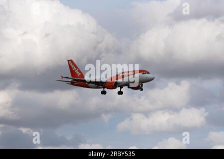 Aereo di linea Airbus A319 easyJet in finale per atterrare all'aeroporto di Londra Stansted, Essex, Regno Unito. Nuvole torreggianti. Aerei all'ombra di nuvole Foto Stock