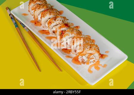 Sushi, panini con caviale, gamberi, tonno e avocado e formaggio Philadelphia, su un piatto bianco. Su uno sfondo colorato. copia spazio Foto Stock