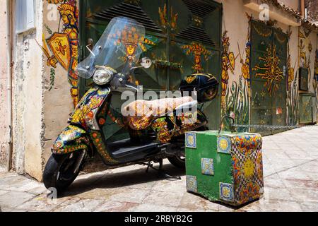 Scene di strada a Taormina, Sicilia - la perla della Sicilia. Un ciclomotore colorato in una strada colorata. Foto Stock