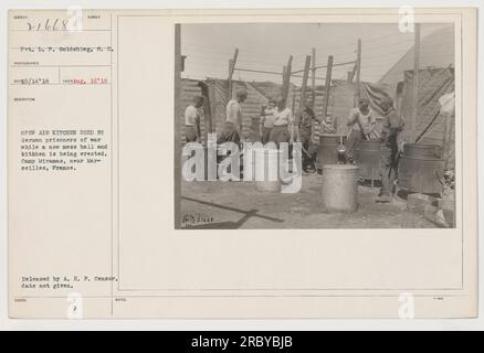 Pvt. L. P. Goldshlag è visibile in questa fotografia scattata il 16 agosto 1918. L'immagine raffigura una cucina all'aperto utilizzata dai prigionieri di guerra tedeschi a Camp Miramas, vicino a Marsiglia, in Francia. La cucina è in uso mentre si stanno costruendo una nuova sala disordinata e una nuova cucina. La fotografia è stata rilasciata dall'A.E.F. Censore, senza data specifica. Foto Stock