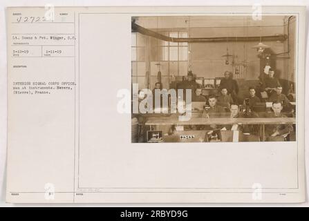 Gli uomini sono visti lavorare in vari strumenti all'interno dell'ufficio Signal Corps a Nevers, in Francia. Questa foto (numero 42722) è stata scattata l'11 gennaio 1919, e il tenente Downs e Pvt. Winger sono identificati nell'immagine. Il fotografo era Mc ma.O. He.SC. Le note per questa foto sono 42722. Foto Stock