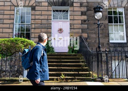 Edimburgo, Scozia, Regno Unito, 11 luglio 2023. La famosa "porta rosa" nella New Town di Edimburgo è stata ridipinta "di bianco" secondo la proprietaria Miranda Dickson. La casa è all'interno di un sito patrimonio dell'umanità dell'UNESCO e il Consiglio comunale di Edimburgo, a seguito di una denuncia, ha minacciato la signora Dickson di una multa grande se non ha ridipinto la porta in un colore più conservativo. La porta riverniciata è stata ora nuovamente ritenuta inopportuna con una nuova denuncia presentata al Consiglio. Iain Masterton/Alamy Live News Foto Stock