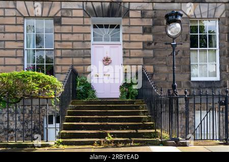 Edimburgo, Scozia, Regno Unito, 11 luglio 2023. La famosa "porta rosa" nella New Town di Edimburgo è stata ridipinta "di bianco" secondo la proprietaria Miranda Dickson. La casa è all'interno di un sito patrimonio dell'umanità dell'UNESCO e il Consiglio comunale di Edimburgo, a seguito di una denuncia, ha minacciato la signora Dickson di una multa grande se non ha ridipinto la porta in un colore più conservativo. La porta riverniciata è stata ora nuovamente ritenuta inopportuna con una nuova denuncia presentata al Consiglio. Iain Masterton/Alamy Live News Foto Stock