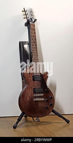 Itterbeck, Germania - giugno 28 2023 Una chitarra elettrica con corpo solido marrone scuro su uno stand di chitarra. E' una Gibson Les Paul Foto Stock