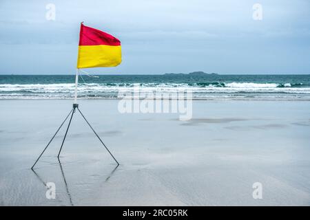 Bandiera del bagnino sulla spiaggia di Whitesands Bay nel Pembrokeshire, Galles Foto Stock
