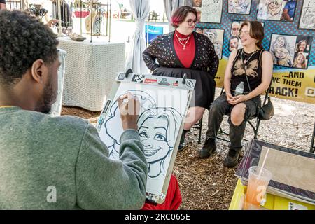 Alpharetta Atlanta Georgia, Alpharetta Arts Streetfest, evento annuale del festival dell'artigianato artistico, artista uomo afro-americano che disegna caricature, woma Foto Stock