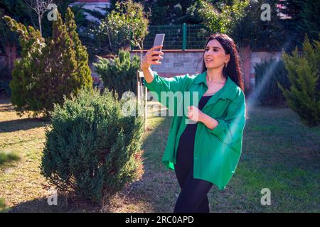 Una bella donna che parla in un parco pubblico Foto Stock