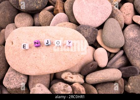 Goditi la parola sulla pietra di ciottoli per lo sfondo e l'ispirazione Foto Stock