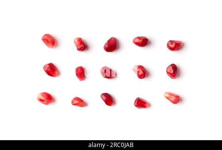 I grani rossi di un melograno maturo sono disposti in modo ordinato su uno sfondo bianco dall'alto. Grani di melograno isolati. Sfondo di semi di melograno. Foto Stock