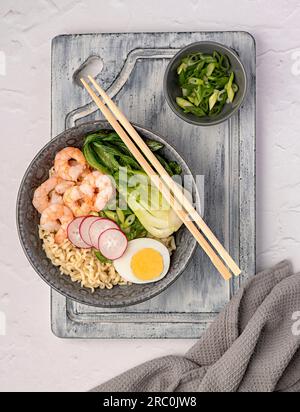 Fotografia gastronomica di ramen di zuppa, uova sode, cipolla, gamberi, spaghetti, gamberi, miso, specialità di pesce, cucina cinese, giapponese, piatto, ciotola, bacchetta Foto Stock
