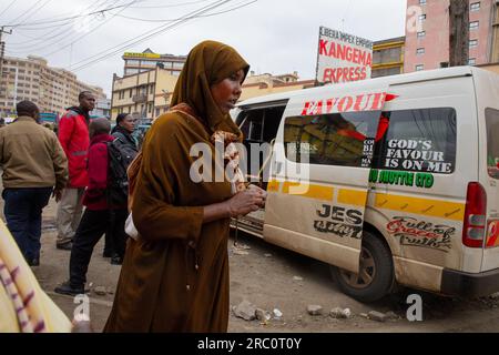 I pedoni camminano oltre le strade trafficate del quartiere centrale degli affari (C.B.D) a Nairobi. Vita quotidiana attraverso le strade di Nairobi, nota come città sotto il sole, privata della parola maasai Enkare, che si traduce in "luogo di acque fresche". Nairobi è la più grande e capitale del Kenya. Foto Stock