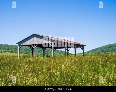 Situato all'interno dello Sky Meadows State Park, Virginia, USA, un fienile all'aperto con un suggestivo tetto rosso si erge con orgoglio. Circondato da tranquilli prati e rolli Foto Stock