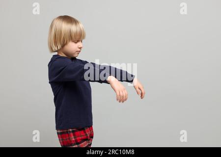 Ragazzo in pigiama che dorma su sfondo grigio chiaro Foto Stock