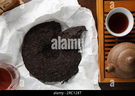 Composizione piatta con tè pu-erh su tavolo in legno Foto Stock