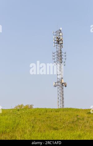 Torre del cellulare - torre della trasmissione del telefono cellulare - sfondo di collina in erba. Preso a Toronto, in Canada. Foto Stock