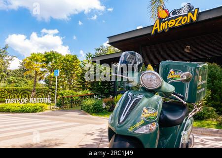 KANCHANABURI-THAILANDIA, 20 ,2020 NOVEMBRE : Green food consegna scooter moto con casco si ferma e attende a casa consegna servizio di fronte Ama Foto Stock