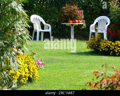 Giardino ornamentale, prato con fiori, bordo floreale, sedie da giardino Foto Stock