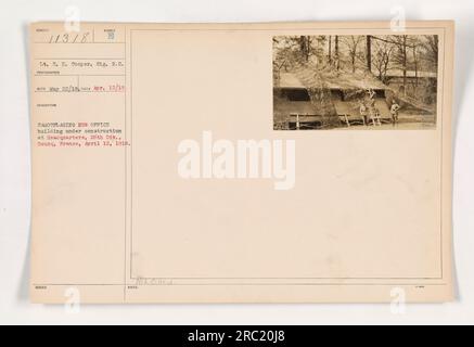 Il tenente E. H. Cooper del Signal Reserve Corps scattò questa foto il 12 aprile 1918. Mostra la costruzione di un nuovo edificio per uffici presso la sede centrale di Boueq, in Francia. La foto cattura il processo di mimetizzazione dell'edificio, che è stato fatto per aiutare a nasconderlo e salvaguardare le operazioni militari. Foto Stock