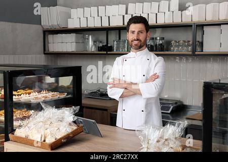 panettiere professionista alla cassa vicino alla vetrina in negozio Foto Stock