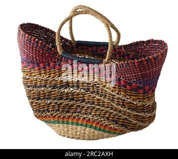 Borsa in vimini in paglia isolata su sfondo bianco. Grande cestello a righe luminose. Accessorio estivo. Foto Stock