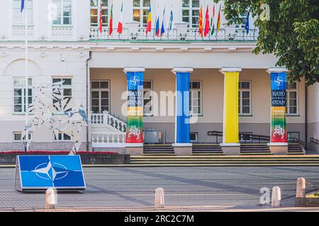 Logo e bandiere dei membri della NATO vicino al palazzo del Presidente che sventolano insieme alla bandiera dell'Ucraina durante la cena del vertice NATO 2023 nel centro di Vilnius Foto Stock