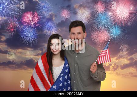 4 luglio - giorno dell'indipendenza dell'America. Buon padre e sua figlia con bandiere nazionali degli Stati Uniti contro il cielo con fuochi d'artificio Foto Stock