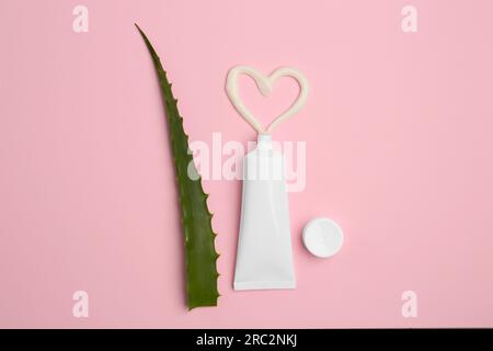 Tubo di dentifricio e aloe fresca su sfondo rosa, disteso Foto Stock