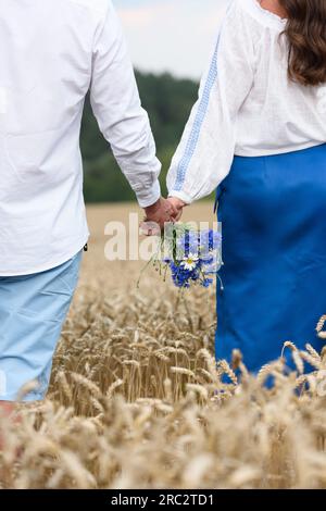 Coppia vestita con abiti tradizionali ucraini che tengono le mani insieme. Matrimonio etnico in costumi nazionali. Foto Stock