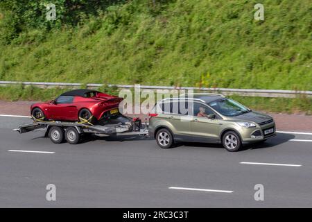 2014 Ford Kuga Zetec 4X2 TDCI TDCI 2WD Green Car SUV Diesel 1997 cc traino 2001 Lotus Elise VVTL-i Maroon Car Roadster benzina 1796 cc su Un rimorchio che viaggia sull'autostrada M6 a Greater Manchester, Regno Unito Foto Stock