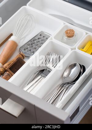 Vassoi Organizer con un set di posate in un cassetto in cucina. Concetto di sistema di storage. Foto Stock