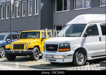 OSTRAVA, REPUBBLICA CECA - 11 MAGGIO 2023: Pulmino passeggeri GMC Savana e SUV Jeep Wrangler davanti alla concessionaria di Ostrava Foto Stock