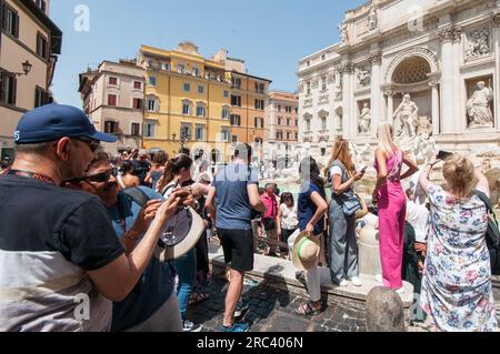 Roma, . 12 luglio 2023. 12/07/2023 Roma: Turisti in Piazza di Trevi con temperature intorno ai 36° PS la foto può essere utilizzata nel rispetto del contesto in cui è stata scattata, e senza intento diffamatorio del decoro delle persone rappresentate. Credito: Agenzia fotografica indipendente/Alamy Live News Foto Stock