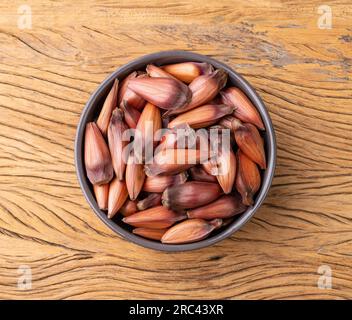 Pignoni o semi di pino su una ciotola su tavola di legno. Foto Stock