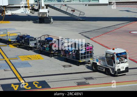 VENEZIA, ITALIA - 22 MAGGIO 2023: Trattore per bagagli con rimorchi pieni di valigie presso l'aeroporto Marco Polo di Venezia in Italia. Si tratta di un'importante a internazionale Foto Stock