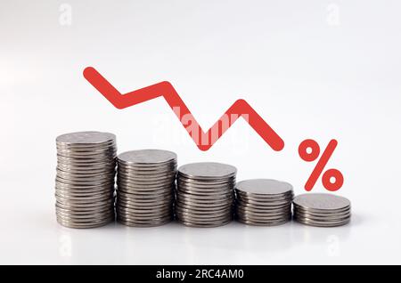 Monete impilamento di denaro con freccia verso il basso e simbolo di percentuale per le banche finanziarie diminuzione degli investimenti o delle imprese. Concetto di business down. Foto Stock