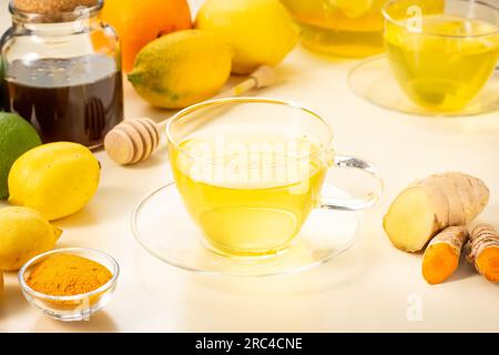 Tè alla curcuma allo zenzero con miele e limone fresco. Infusione naturale di erbe per il freddo e l'immunità. Tazza calda di tè. Foto Stock
