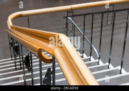 Foto ravvicinata con corrimano curvo in legno con soft focus selettivo, architettura moderna Foto Stock