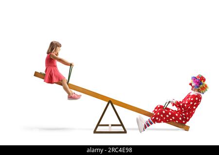 Bambina che gioca su una seesaw con un clown isolato su sfondo bianco Foto Stock