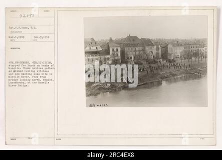 I soldati americani della quarta divisione Engineers pranzano sulle rive del fiume Mosella a Remich, in Lussemburgo. La foto raffigura i nativi riuniti intorno alle cucine rotolanti e i soldati che lavano i loro kit di disordine nel fiume. La vista è dal ponte che guarda a nord. Presa il 3 dicembre 1918. Foto Stock