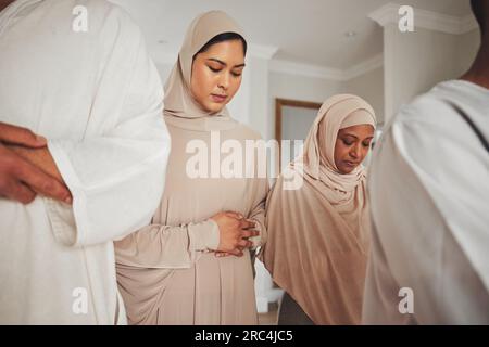 Preghiera, musulmana e islamica con donne in soggiorno per eid mubarak, Dio e culto. Corano, speranza e Ramadan con famiglia spirituale che prega dua at Foto Stock
