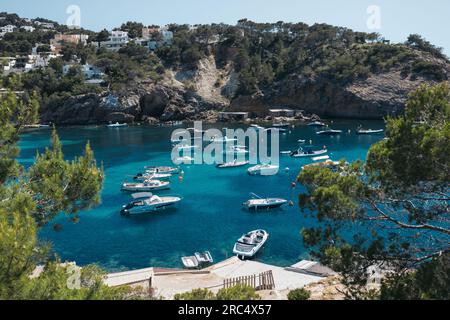 Pittoresco paesaggio marino della baia con barche da pesca bianche nell'oceano blu nel fine settimana estivo in un resort tropicale sulle Isole Baleari Foto Stock