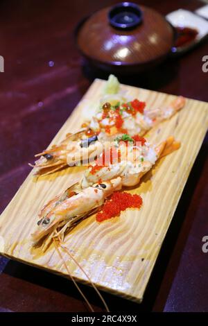Primo piano di cucina giapponese, piatto di gamberi botan cucinato. Top con Tobiko (uova di pesce volanti) e uova di salmone splendidamente disposte su una sala Foto Stock