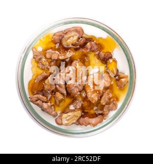 Yogurt greco con miele e noci arrostite, in un vaso di vetro. Yiaourti me meli, un dolce tradizionale, un dessert e uno spuntino, fatto di yogurt cremoso e agitato. Foto Stock